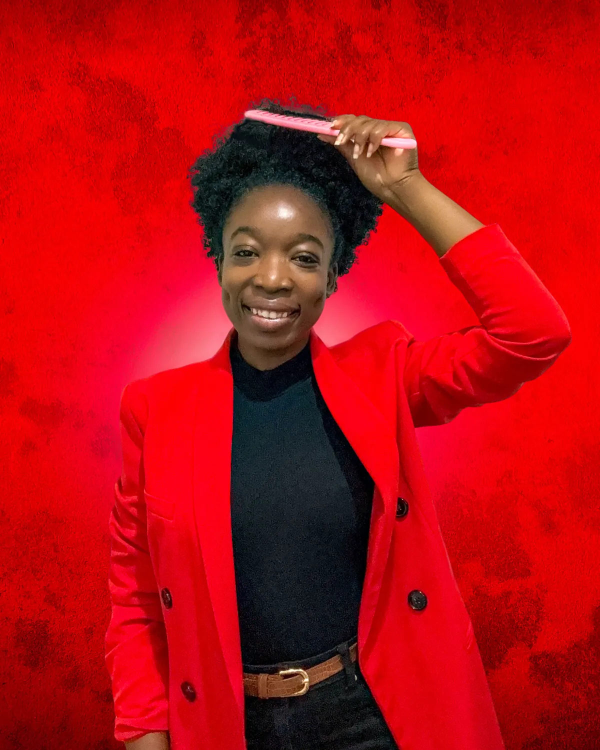 Portrait de la fondatrice de FIMANI, en blazer rouge, un peigne rose dans ses cheveux.